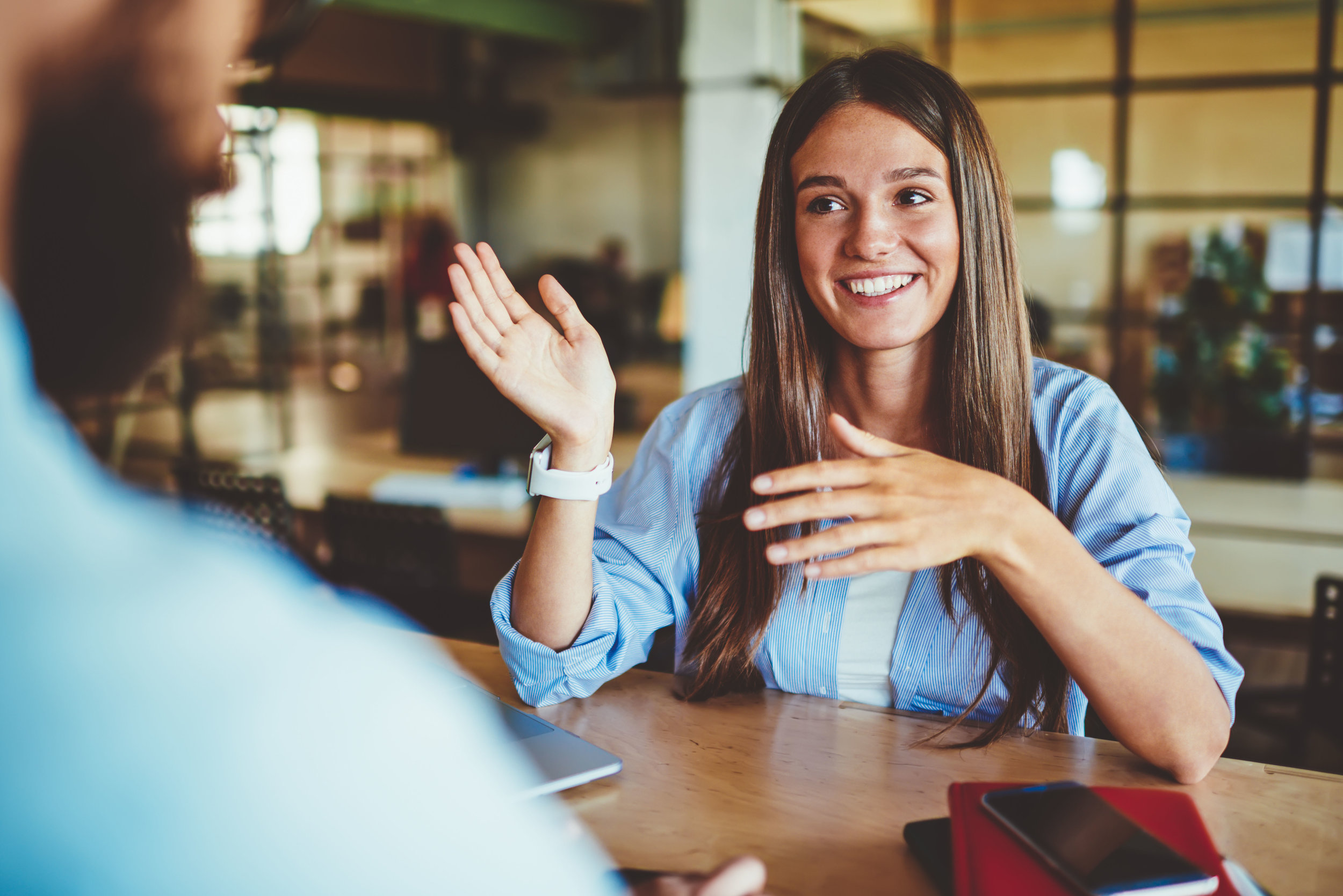 A woman speaking to a man in an office setting.