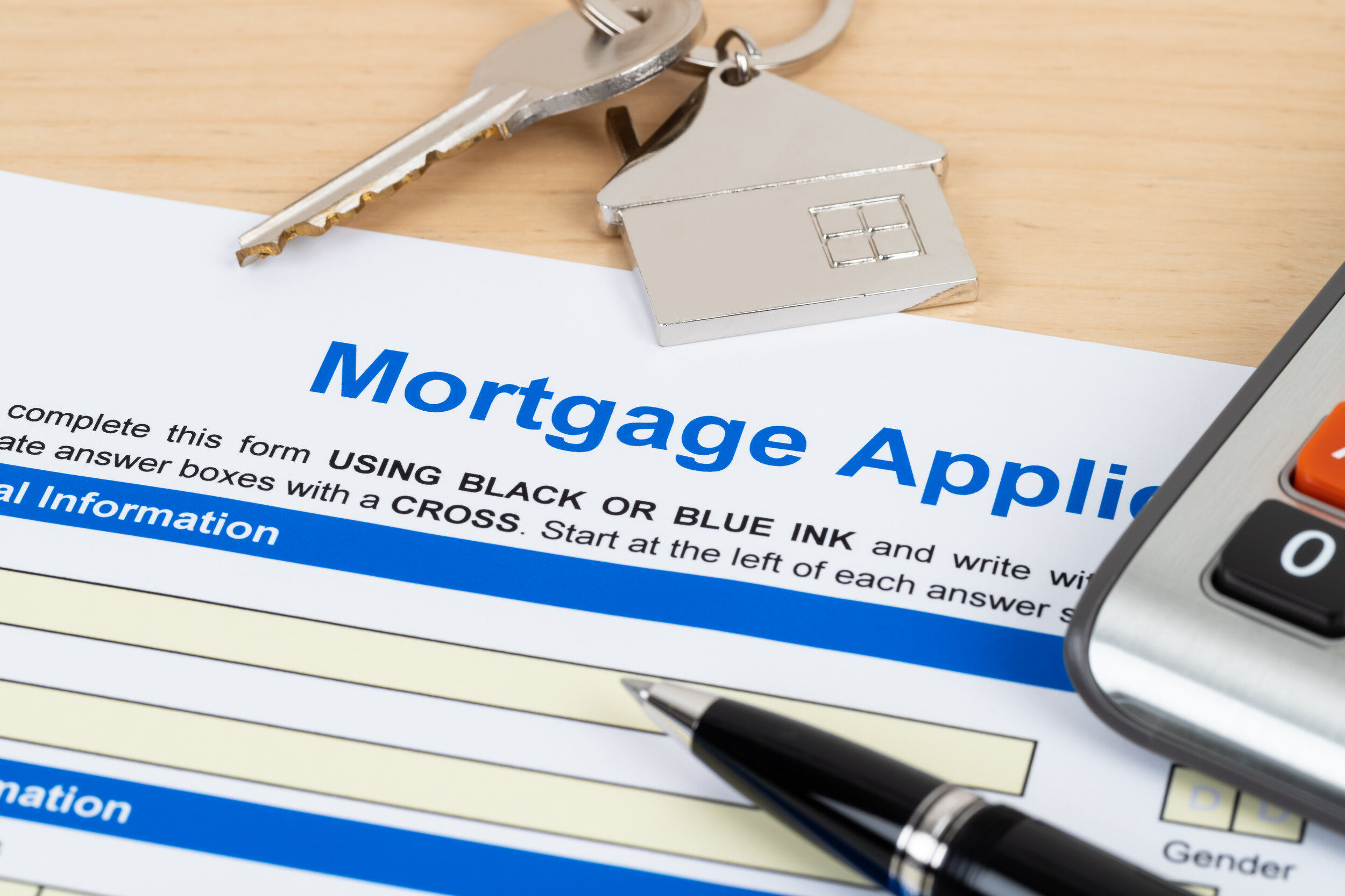 A mortgage application with house keys on it.