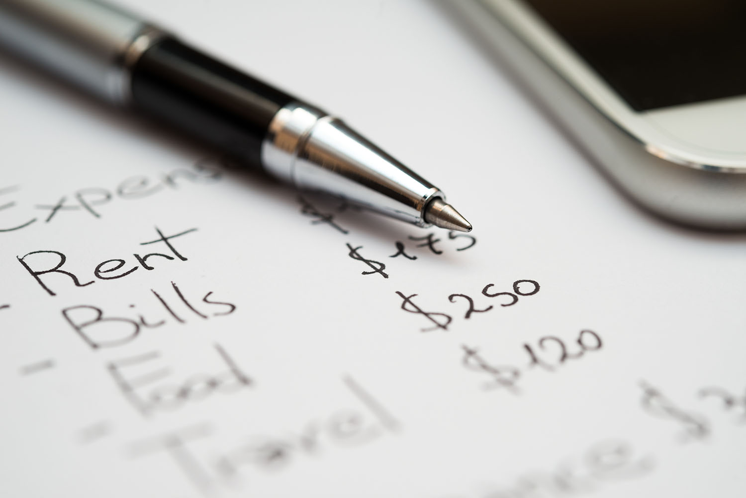 A budgeting notebook with a pen and phone.