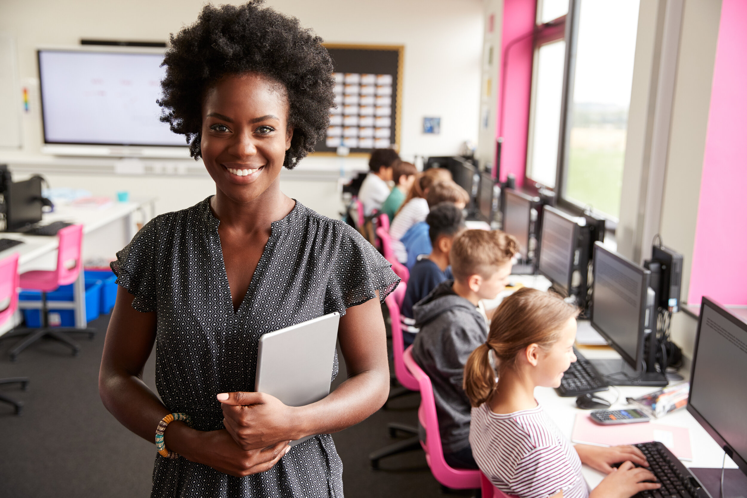 A woman in an elementary class smiling.