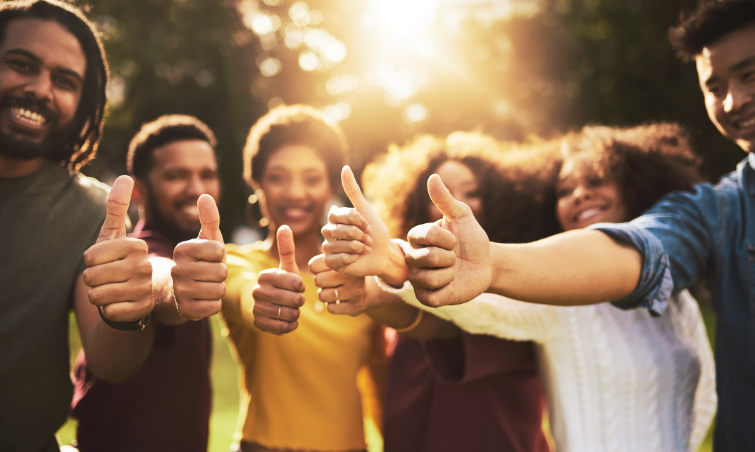 group of smiling people with thumbs up