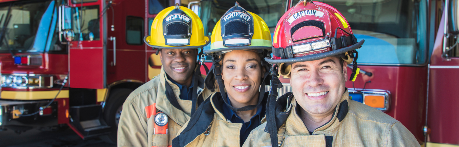 group of firefighters smiling in front of fire truck