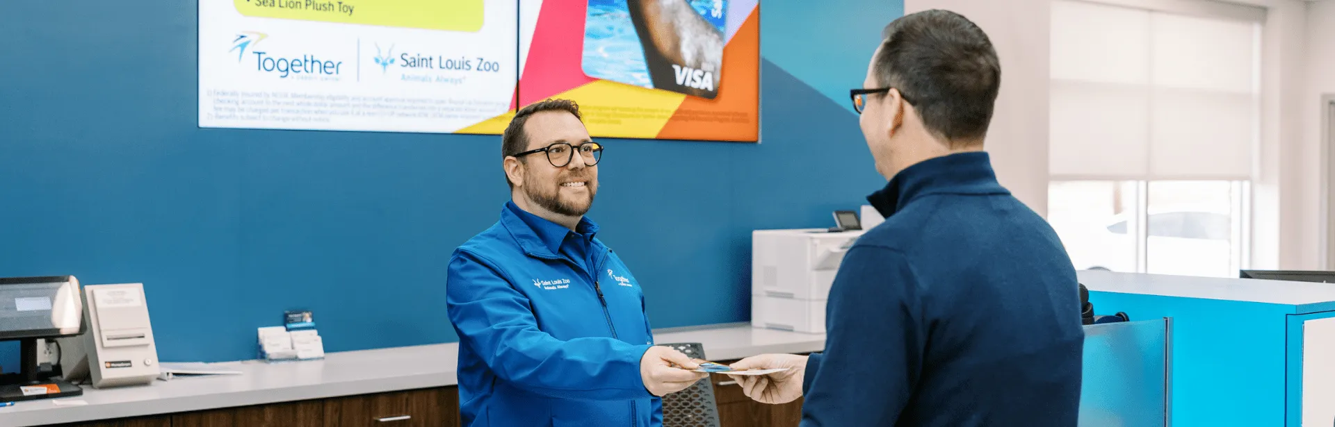 An employee exchanging an ID with a customer inside of a Together Credit Union location.